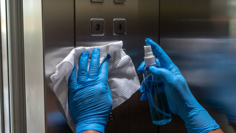 Close up of female hand using wet wipe and alcohol sanitizer spr
